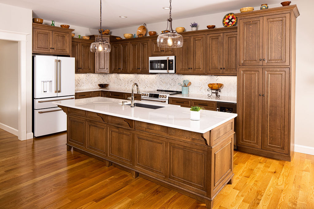 "Traditional Amish kitchen cabinets in oak with raised panel doors."